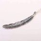 Silver feather-shaped pendant on a white background