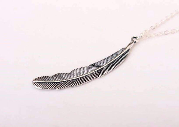 Silver feather-shaped pendant on a white background