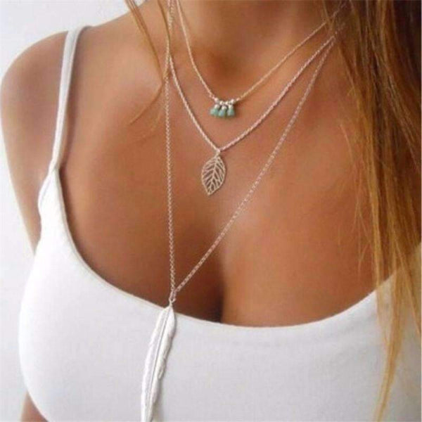 Layered necklaces with leaf pendants on a white background