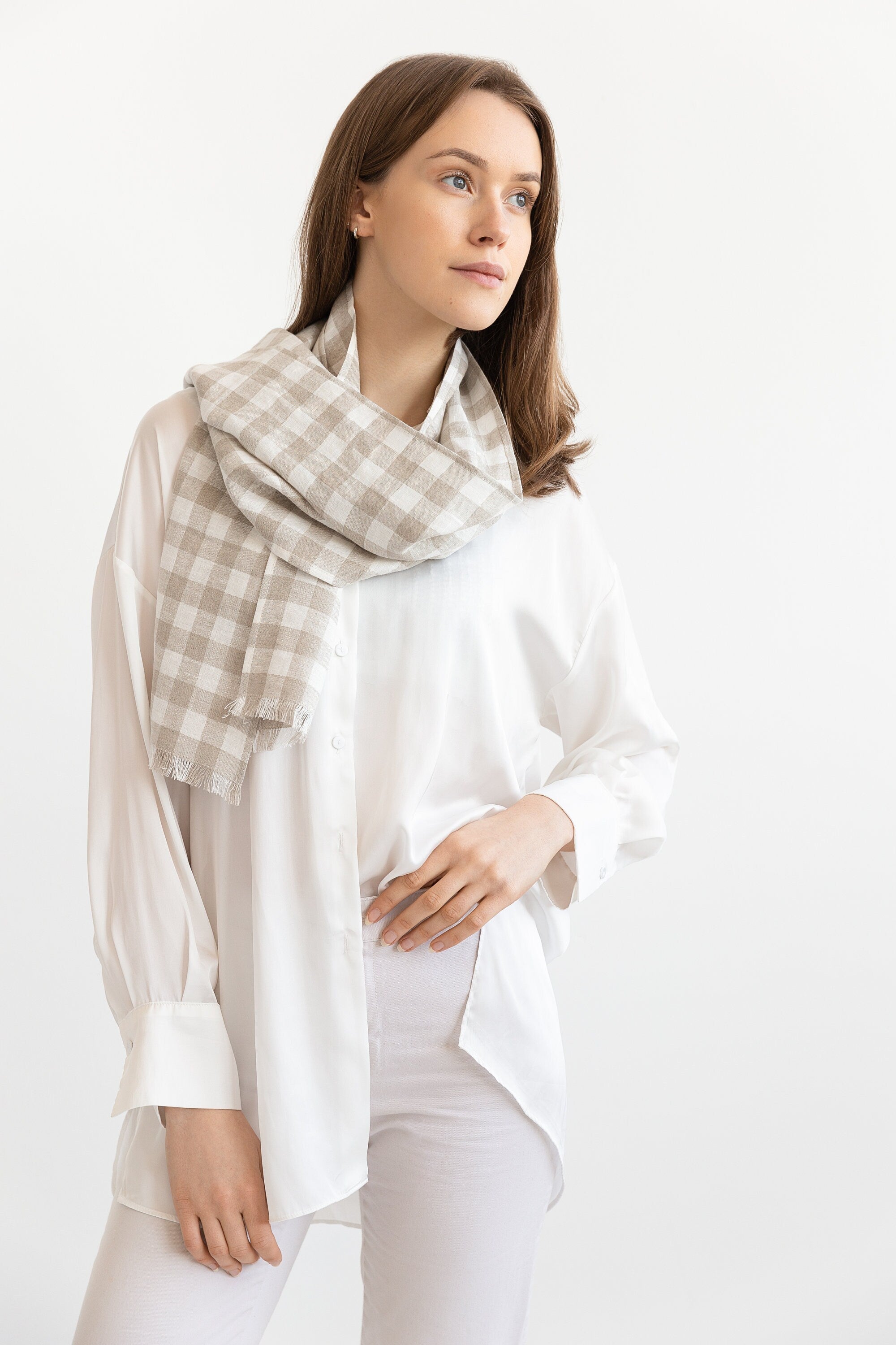 Woman wearing a plaid scarf on a white background