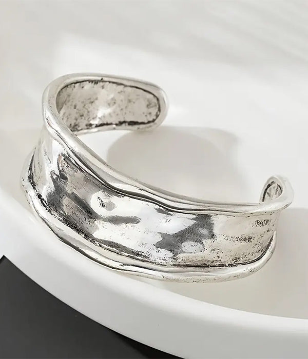 Silver cuff bracelet on a white surface