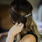 Person adjusting a hair accessory with beads in their hair