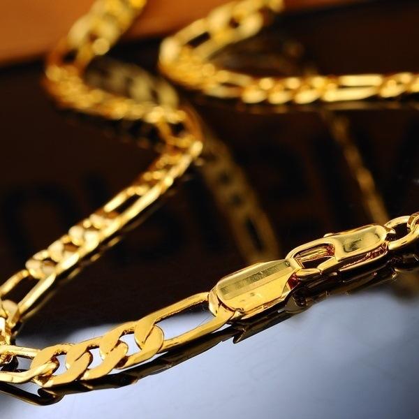 Gold chain on a reflective surface with a blurred background