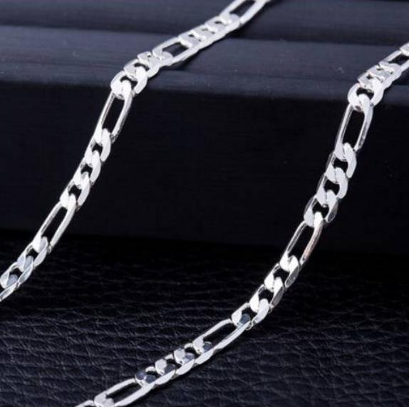Silver chain necklace on a dark textured surface