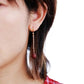 Close-up of a person wearing a red earring with a white background