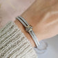 Silver bracelet on a wrist with a blurred background