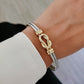 Gold and silver bracelet on a wrist with a blurred background