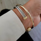Gold and silver bracelets on a wrist with a blurred background