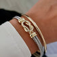 Gold and silver bracelet on a wrist with a blurred background