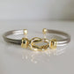 Gold and silver bracelet on a light gray background