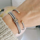 Close-up of a wrist wearing multiple bracelets on a neutral background
