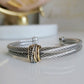 Silver bracelet with a gold accent on a white surface