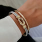 Gold bracelet on a wrist with a blurred background