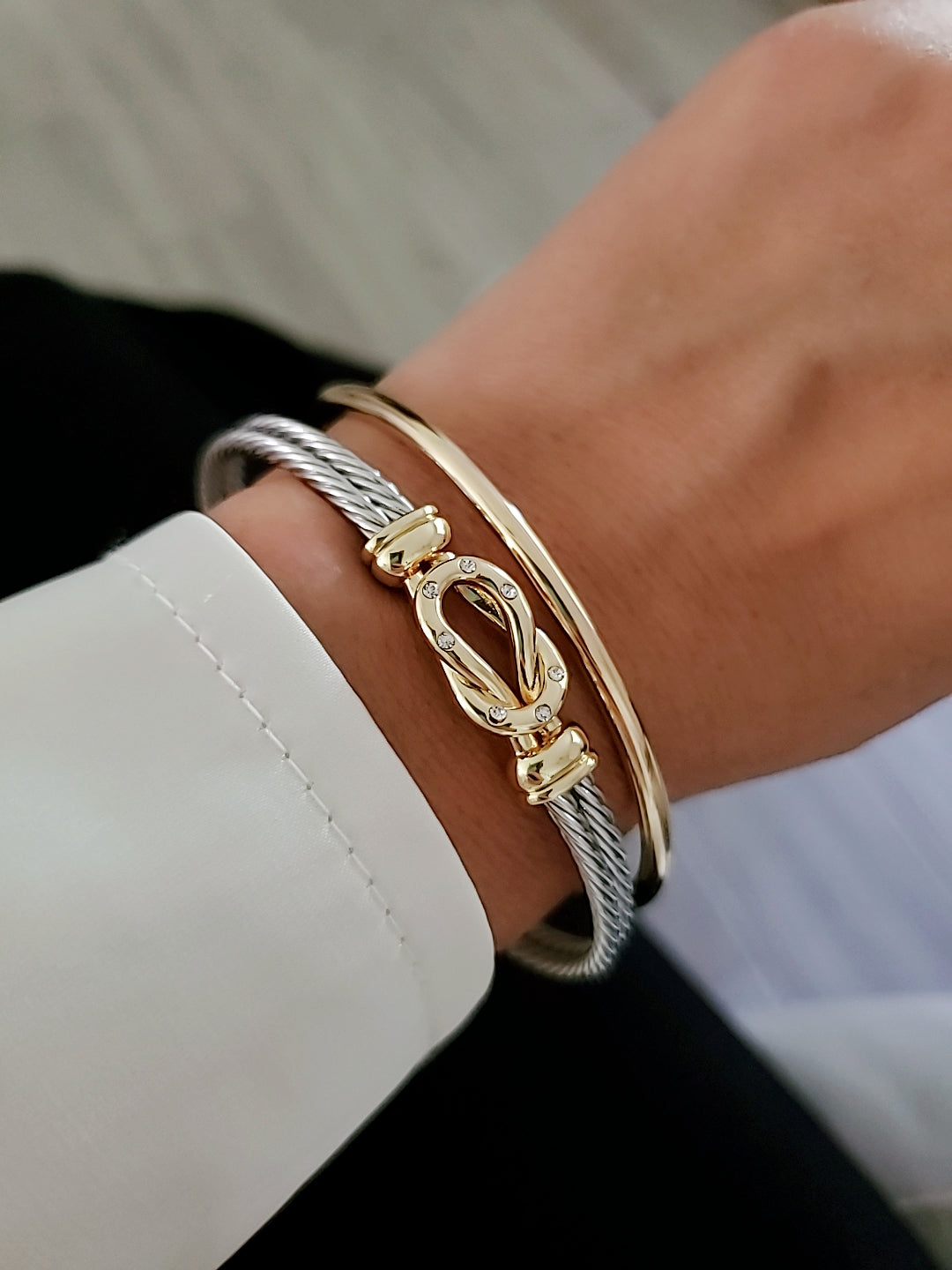 Gold bracelet on a wrist with a blurred background