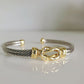 Gold and silver bracelet on a light gray background