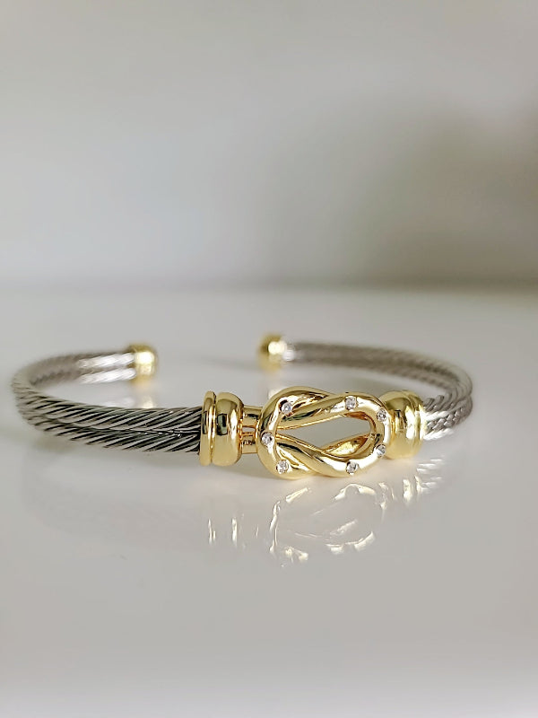 Gold and silver bracelet on a light gray background
