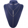Silver necklace on a blue mannequin bust