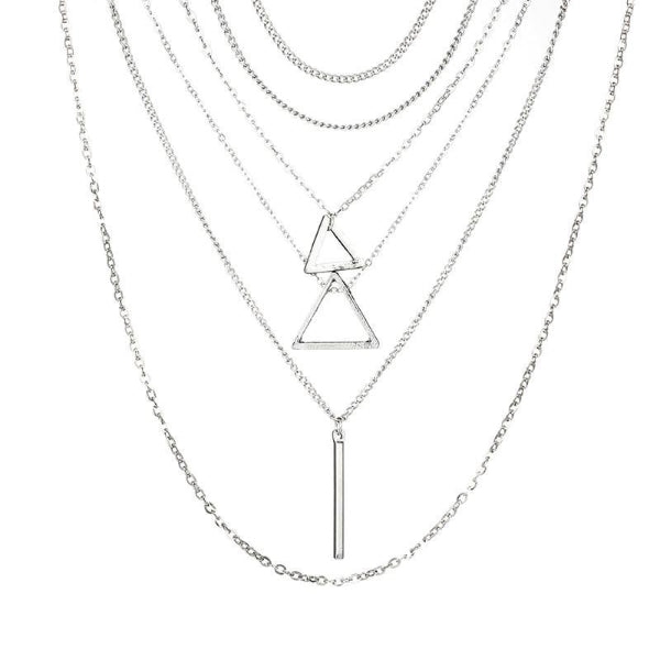 Stack of silver necklaces with geometric pendants on a white background