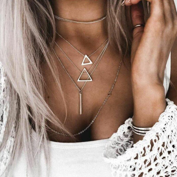 Necklace with triangle pendants worn by a person with white lace garment