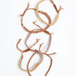 Set of braided bracelets with shell accents on a white background