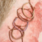 Gold hoop earrings on a pink stone background